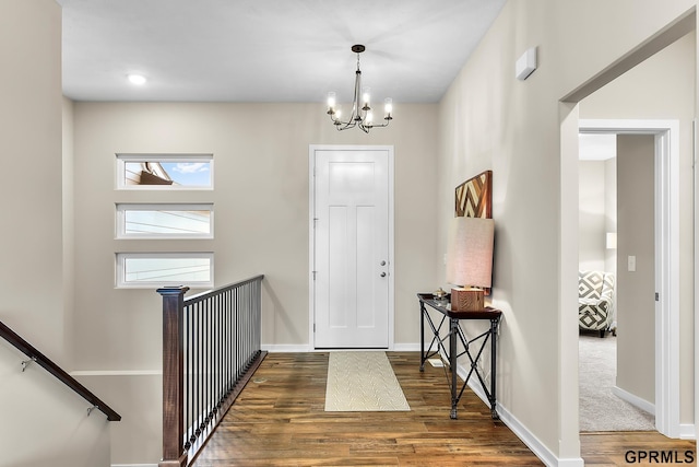 entryway with dark hardwood / wood-style flooring and a notable chandelier