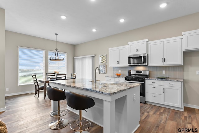 kitchen featuring white cabinetry, sink, a center island with sink, and appliances with stainless steel finishes