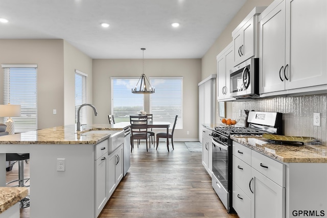 kitchen with white cabinets, pendant lighting, and stainless steel appliances