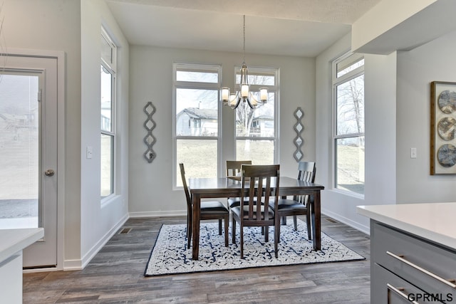 dining area featuring dark hardwood / wood-style flooring, a textured ceiling, and a chandelier