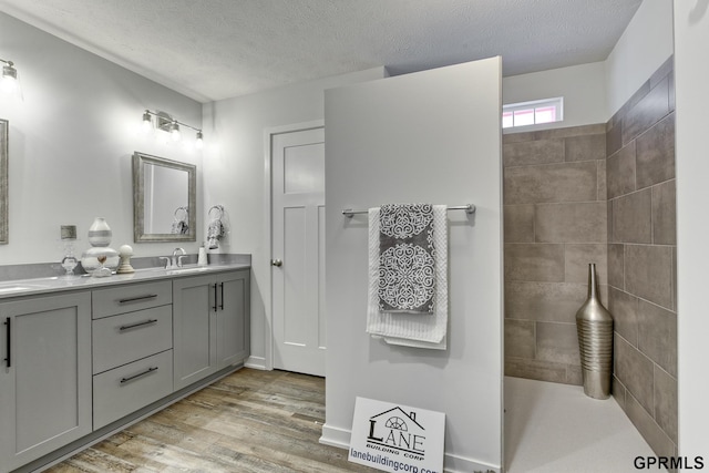 bathroom featuring vanity, hardwood / wood-style floors, and a textured ceiling