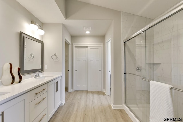 bathroom featuring vanity, wood-type flooring, and walk in shower