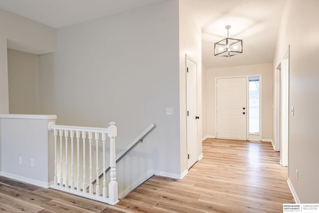 foyer featuring light wood-type flooring and an inviting chandelier