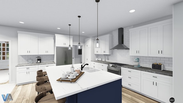 kitchen with wall chimney exhaust hood, stainless steel appliances, sink, white cabinets, and an island with sink