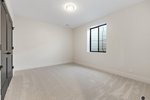 carpeted empty room with a textured ceiling