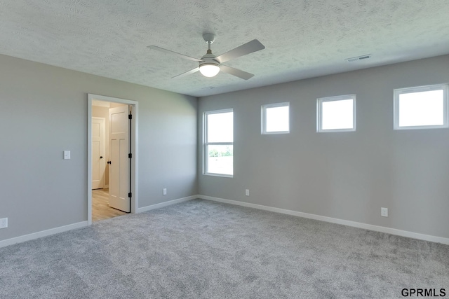 carpeted empty room with ceiling fan and a textured ceiling