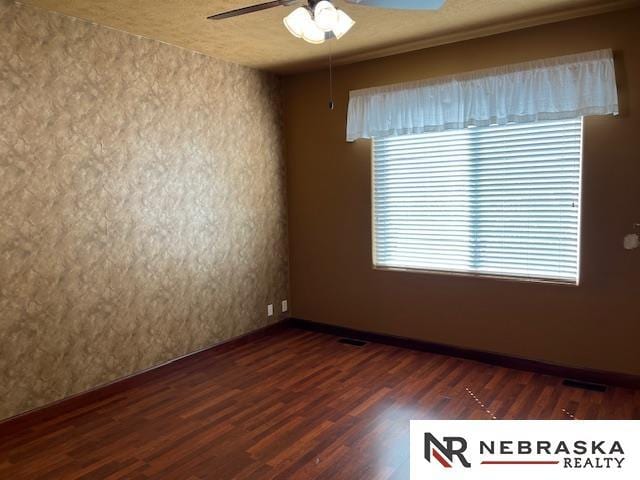 spare room featuring a textured ceiling, dark hardwood / wood-style floors, ceiling fan, and crown molding