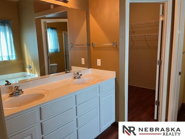 bathroom with a bathing tub, vanity, and wood-type flooring