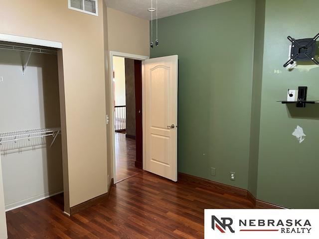 unfurnished bedroom with a closet and dark wood-type flooring