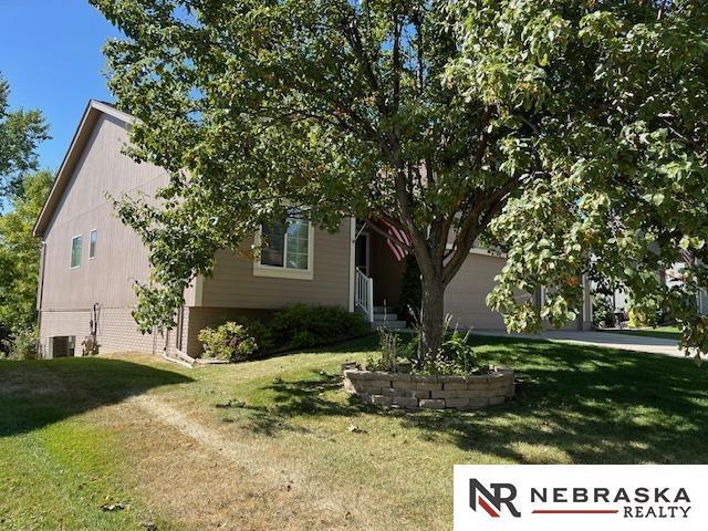 view of property hidden behind natural elements featuring a front yard