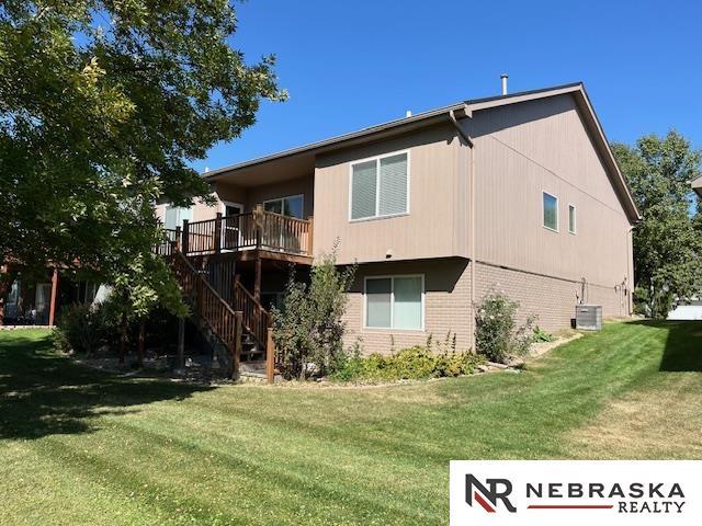 back of house with a wooden deck, a yard, and cooling unit