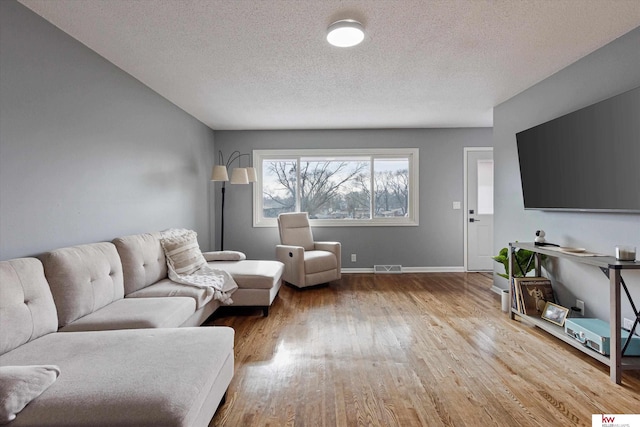 living room featuring a textured ceiling and hardwood / wood-style flooring