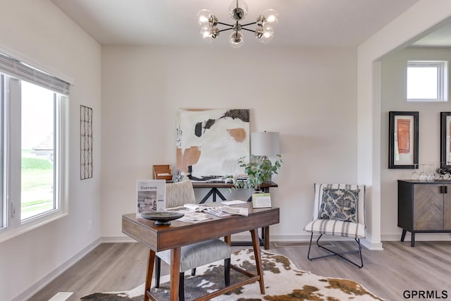 office area with a notable chandelier, a healthy amount of sunlight, and light hardwood / wood-style floors