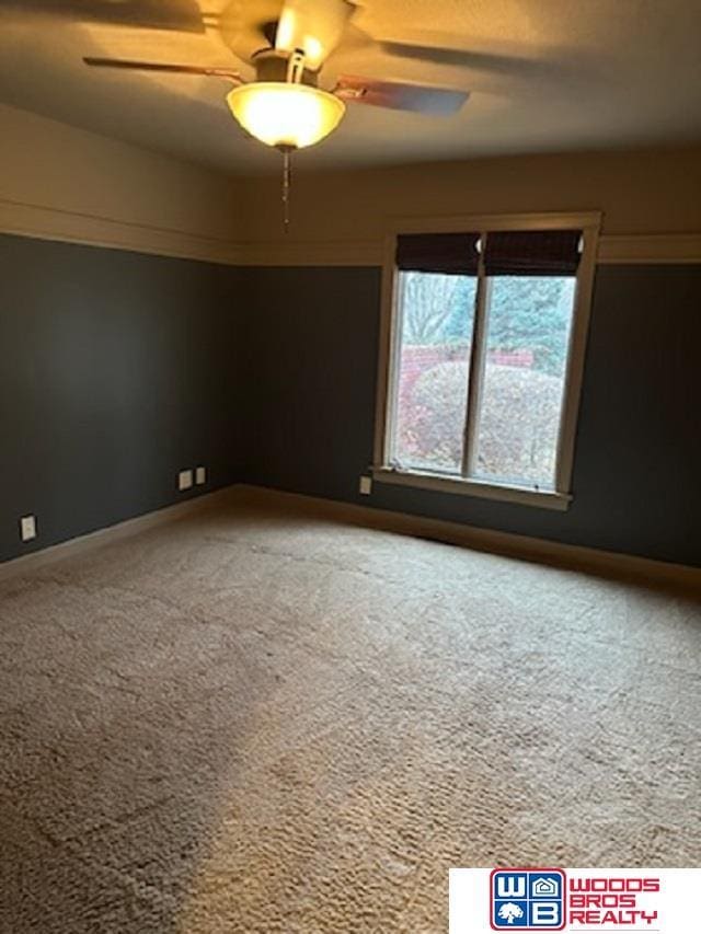 spare room featuring ceiling fan and carpet