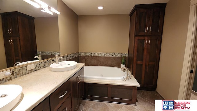 bathroom with tile patterned flooring, vanity, and a washtub