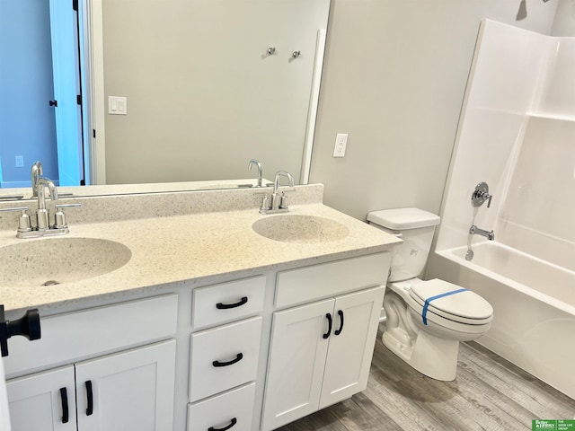 full bathroom with shower / bathing tub combination, hardwood / wood-style flooring, vanity, and toilet