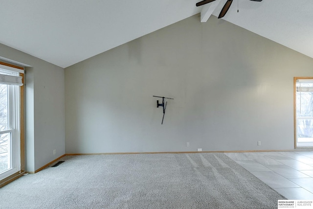 spare room featuring light carpet, lofted ceiling with beams, plenty of natural light, and ceiling fan