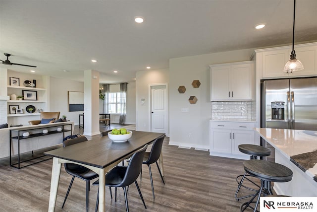 dining space with ceiling fan and dark wood-type flooring