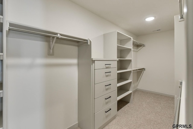 walk in closet featuring light colored carpet