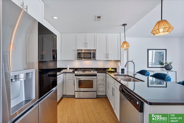 kitchen with white cabinets, pendant lighting, stainless steel appliances, and sink