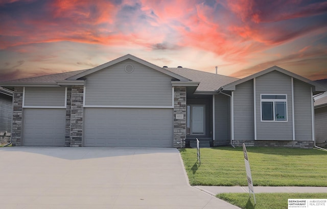 ranch-style house featuring a lawn and a garage