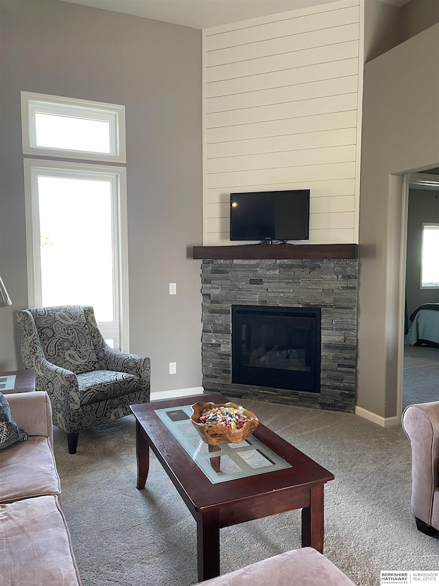 living room featuring carpet flooring and a stone fireplace