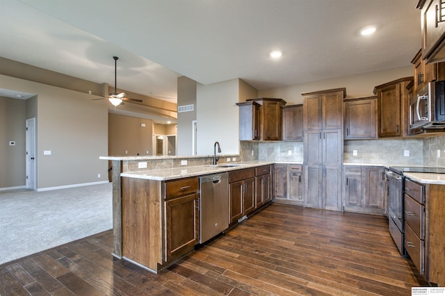 kitchen featuring decorative backsplash, light stone countertops, sink, and stainless steel appliances