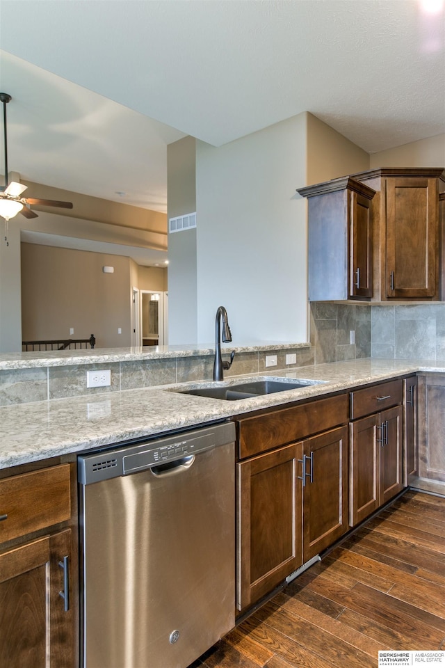 kitchen with decorative backsplash, light stone counters, stainless steel dishwasher, sink, and dark hardwood / wood-style floors