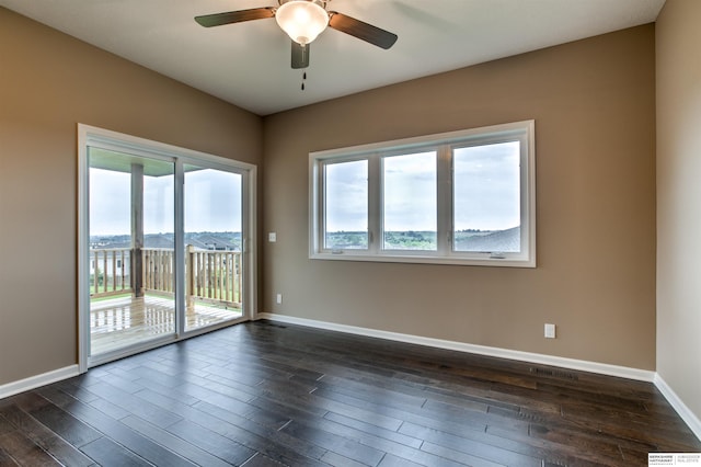 unfurnished room featuring ceiling fan, dark hardwood / wood-style floors, and a mountain view