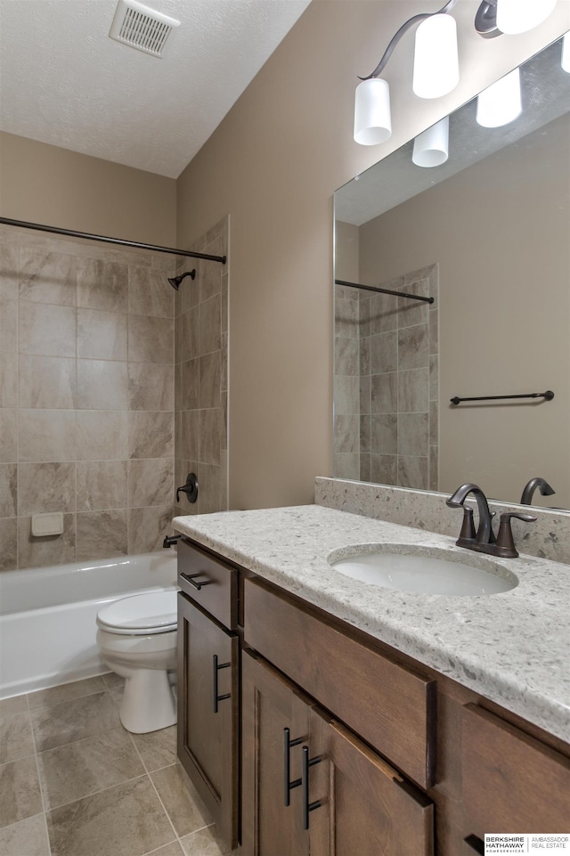 full bathroom with tile patterned flooring, vanity, toilet, and tiled shower / bath combo