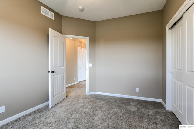 unfurnished bedroom with light carpet and a closet