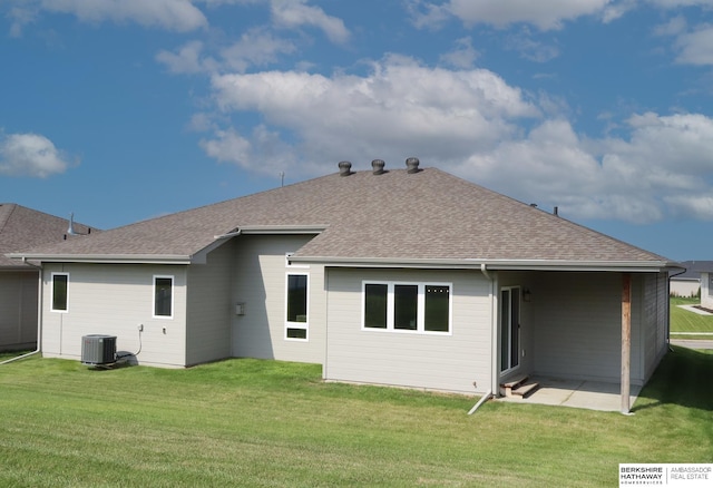 rear view of house featuring a lawn, cooling unit, and a patio