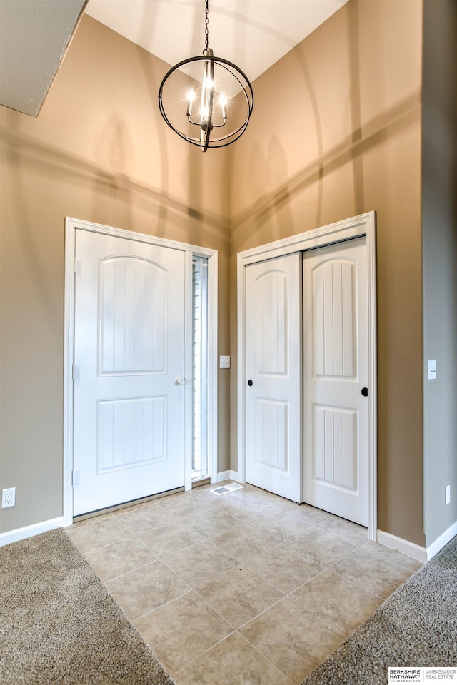 tiled foyer featuring an inviting chandelier