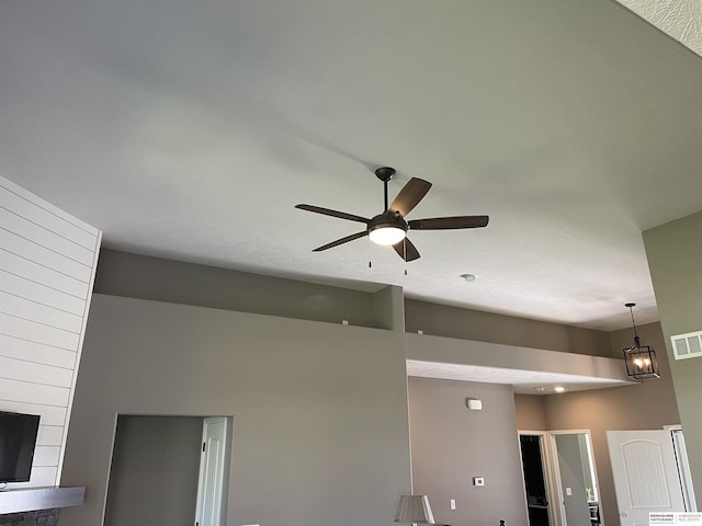 interior details featuring ceiling fan with notable chandelier