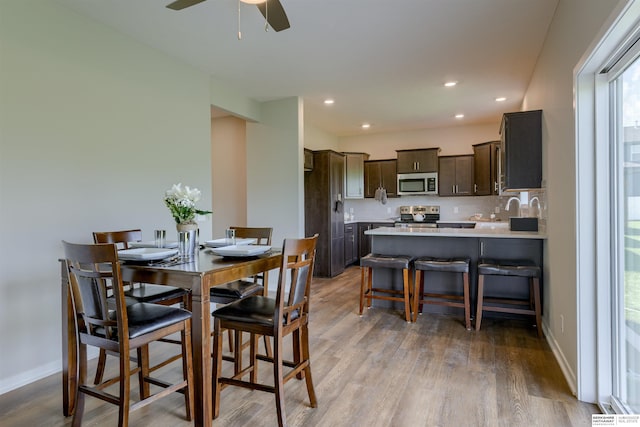 dining area featuring wood-type flooring and ceiling fan