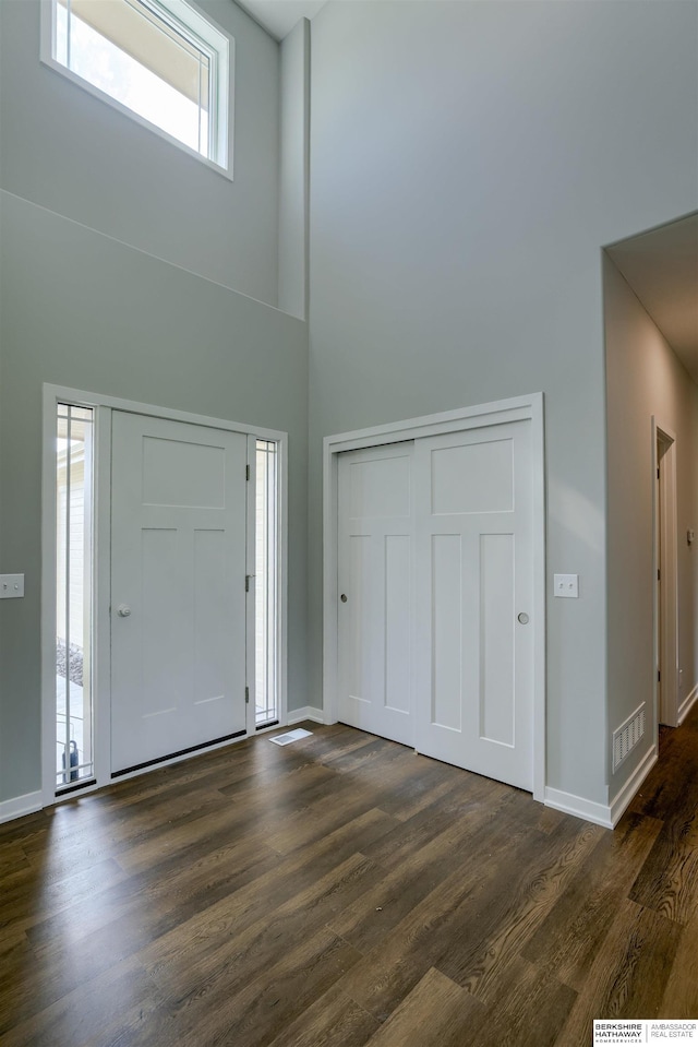 entrance foyer with a high ceiling and dark hardwood / wood-style flooring