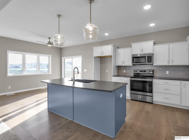 kitchen featuring stainless steel appliances, white cabinetry, hanging light fixtures, and sink