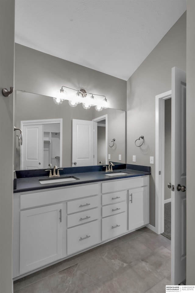 bathroom with vanity, tile patterned floors, and lofted ceiling