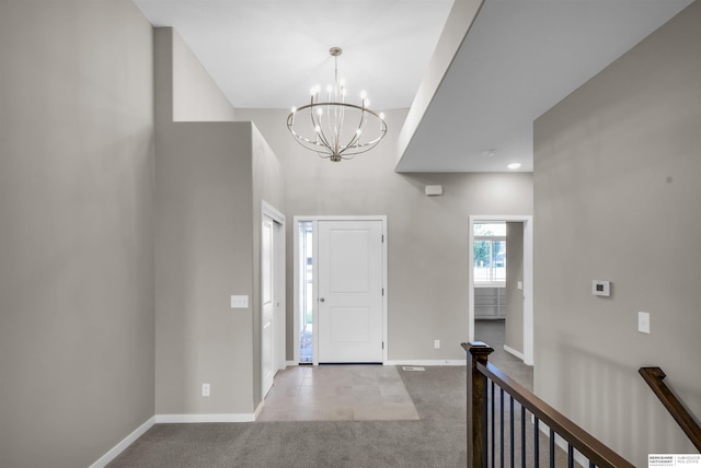 entrance foyer featuring light carpet and a chandelier