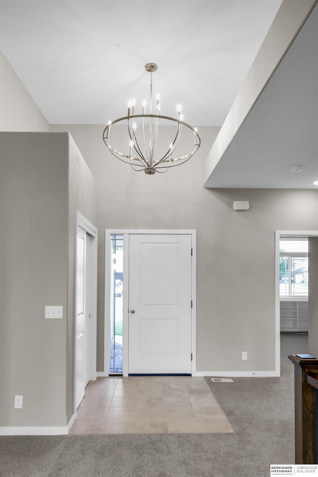 entrance foyer featuring light colored carpet and an inviting chandelier