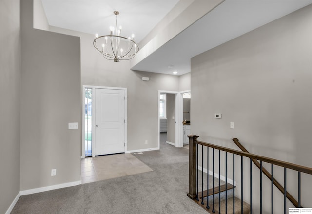 foyer entrance featuring light carpet and a notable chandelier