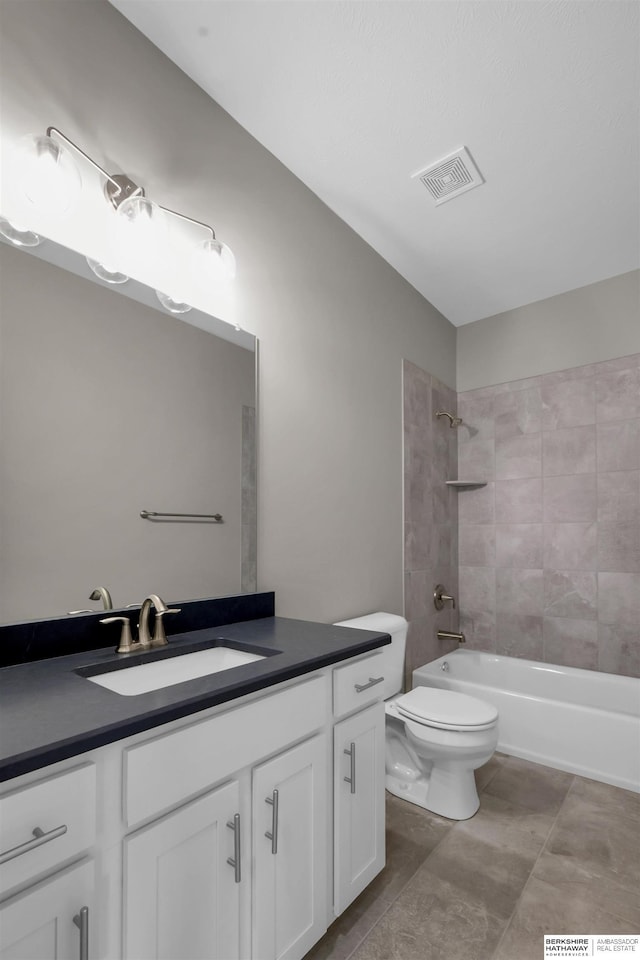 full bathroom with tiled shower / bath combo, toilet, and vanity