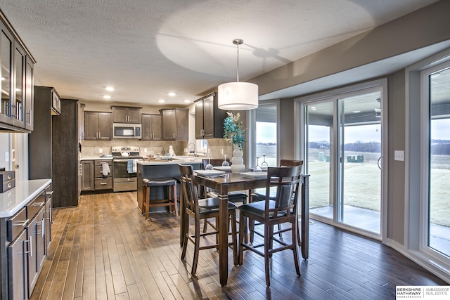 dining room featuring dark wood-type flooring and a textured ceiling