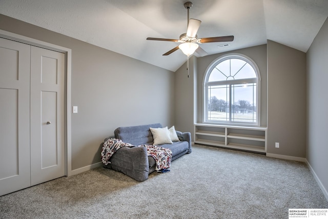 living area featuring carpet, ceiling fan, and vaulted ceiling