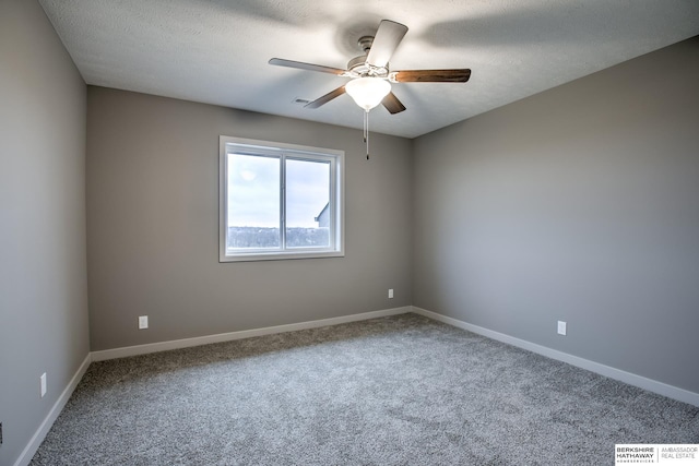 carpeted spare room featuring a textured ceiling and ceiling fan