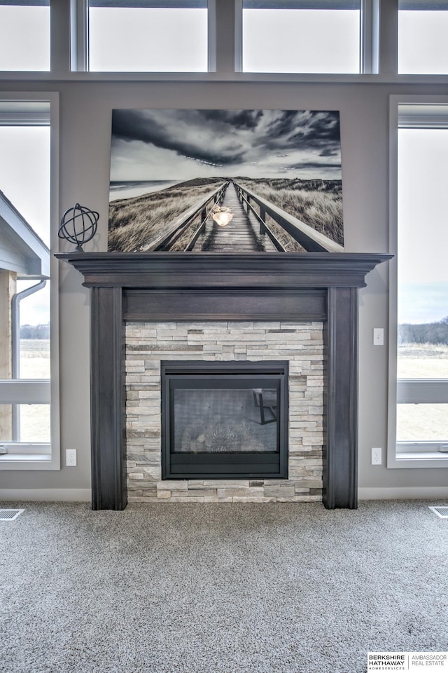 interior details with a tile fireplace and carpet floors