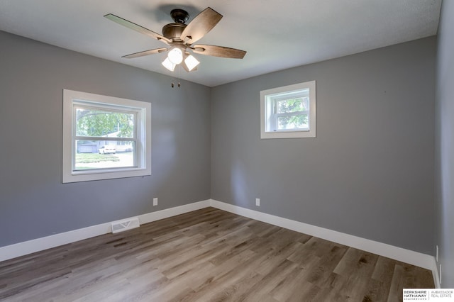 unfurnished room with ceiling fan, a healthy amount of sunlight, and light wood-type flooring