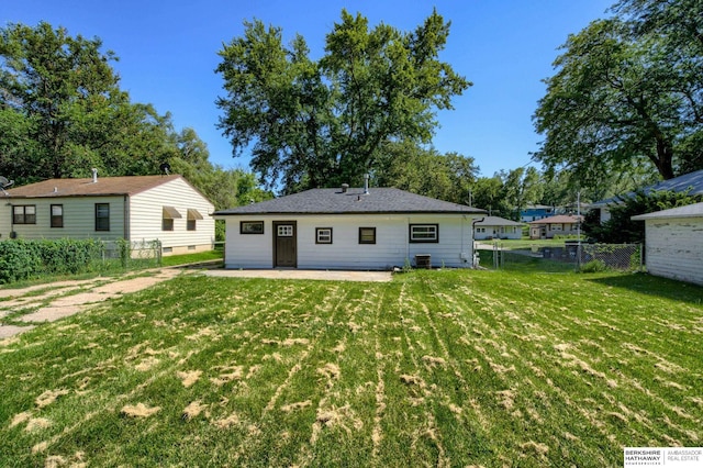 back of house featuring a lawn and a patio area