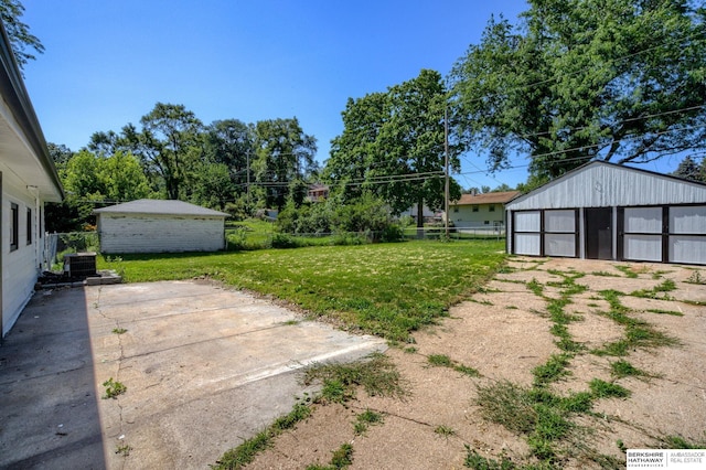 view of yard featuring central AC unit and an outbuilding