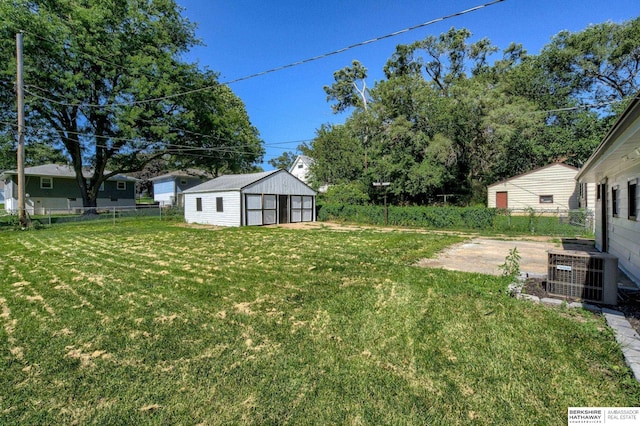 view of yard featuring central AC and an outdoor structure